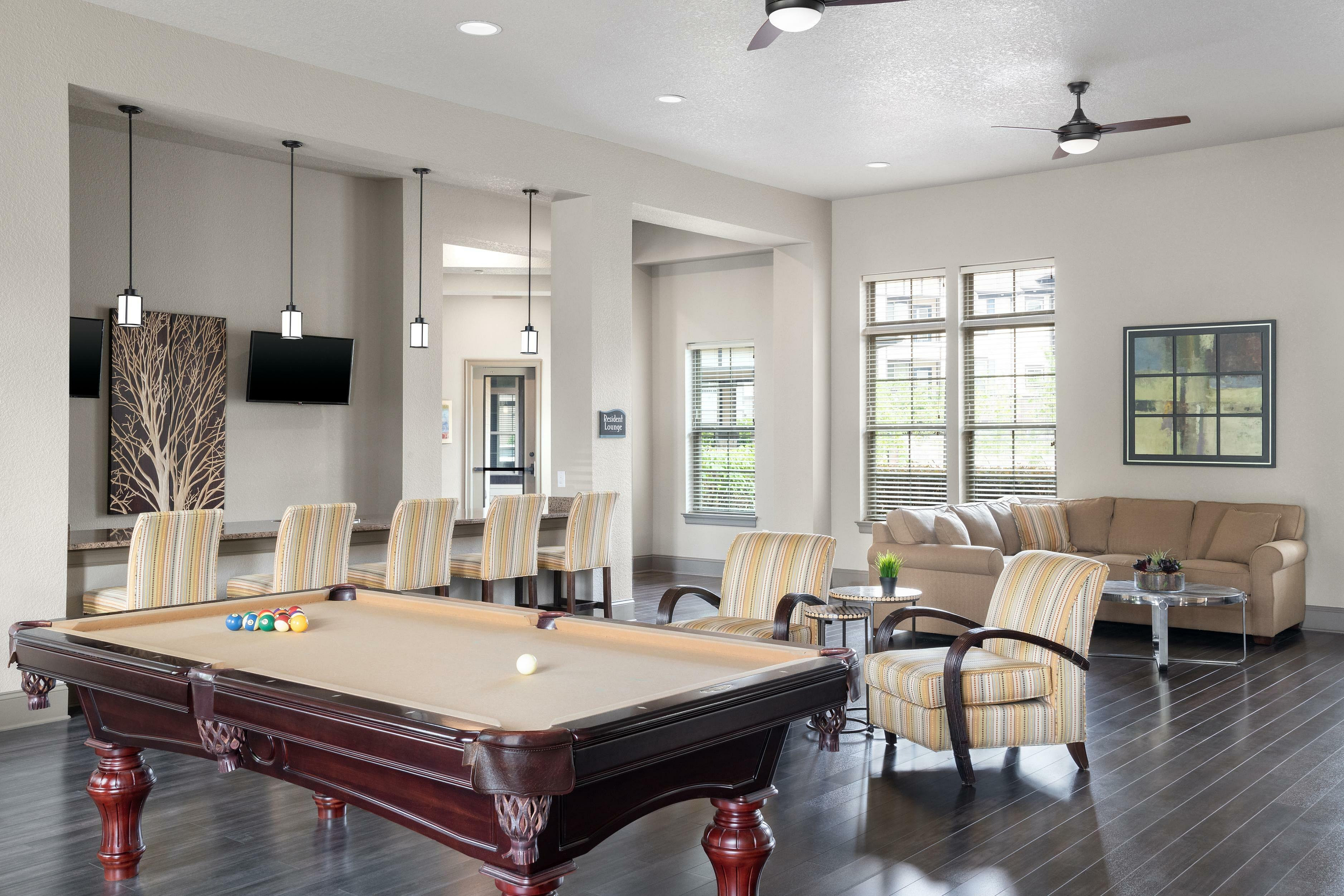 Chic recreation room with billiards table, seating area, and modern decor.