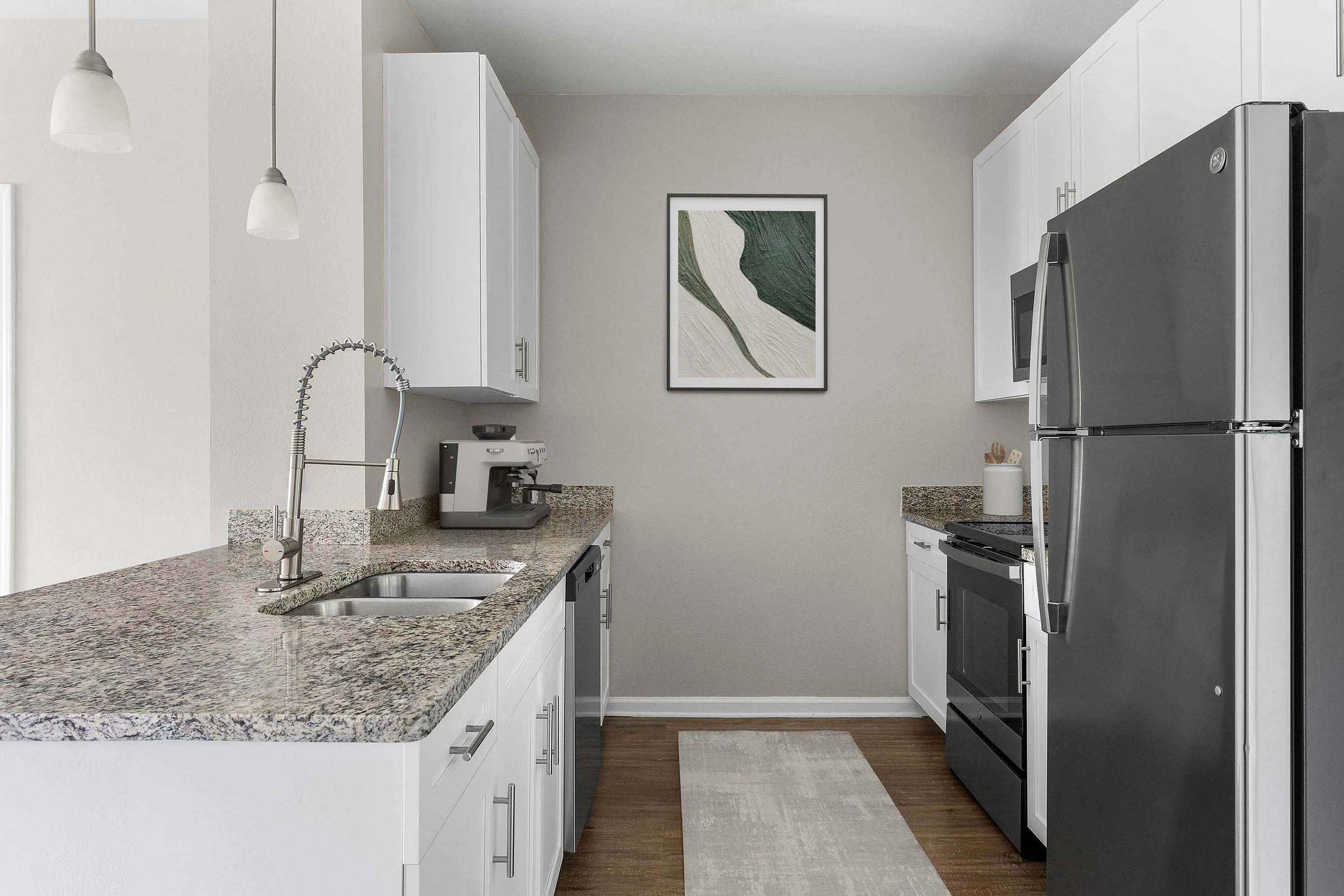 Sleek kitchen design with granite countertops, stainless steel appliances, and white cabinetry.