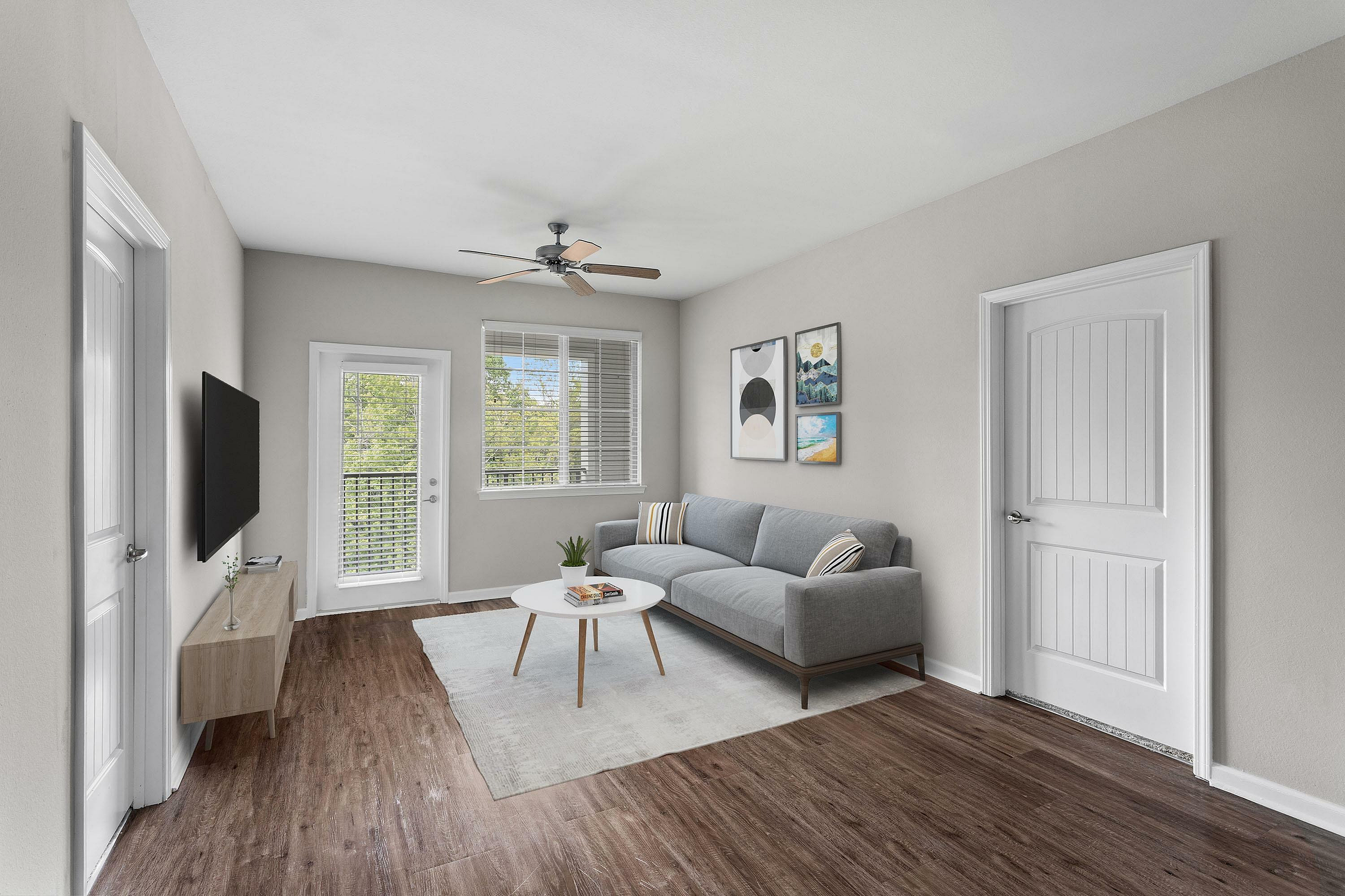 Stylish living room with a sleek gray sofa, wooden floor, and modern decor.