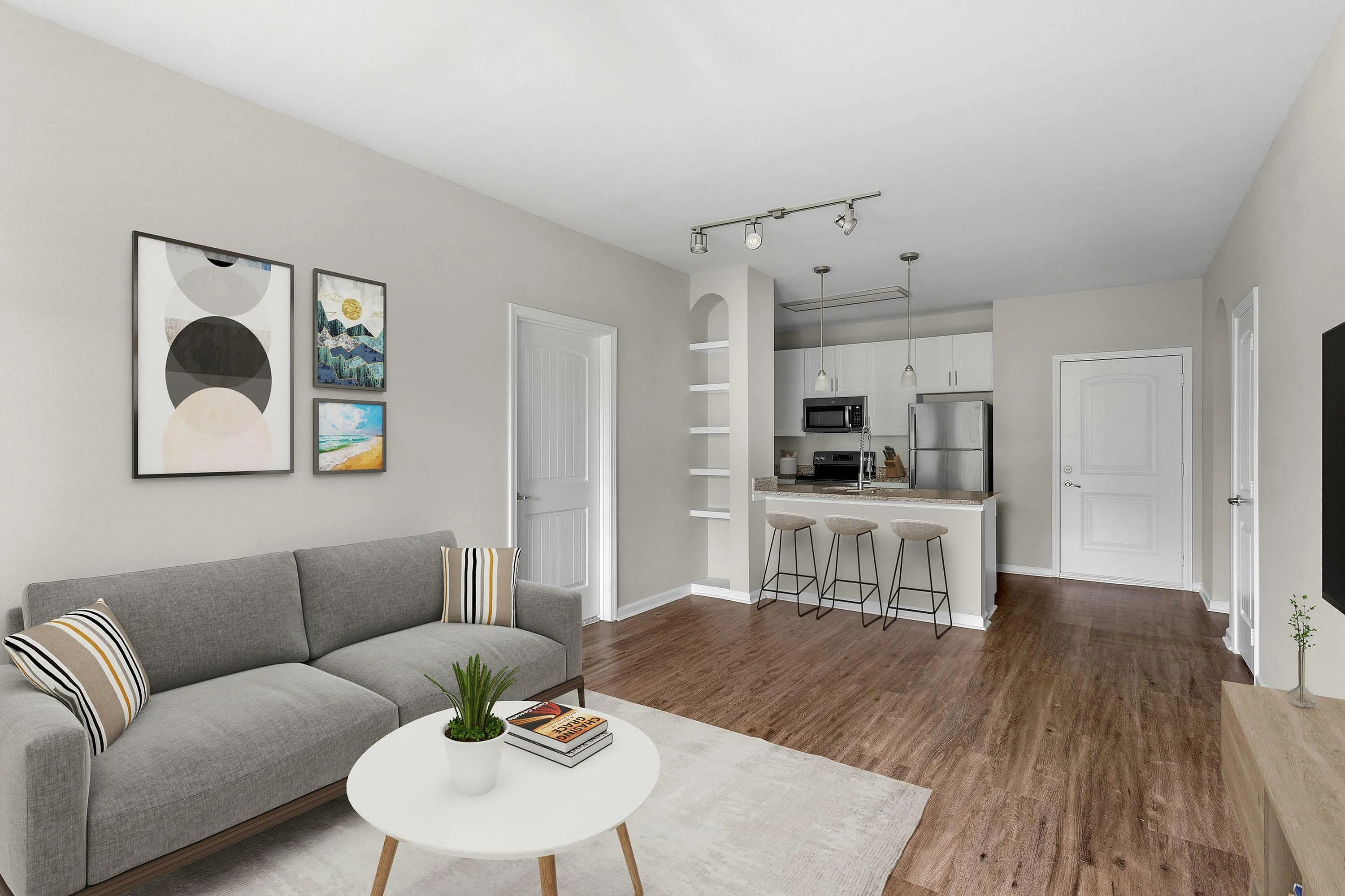 Stylish living room with a modern gray sofa, chic artwork, and an open kitchen design.
