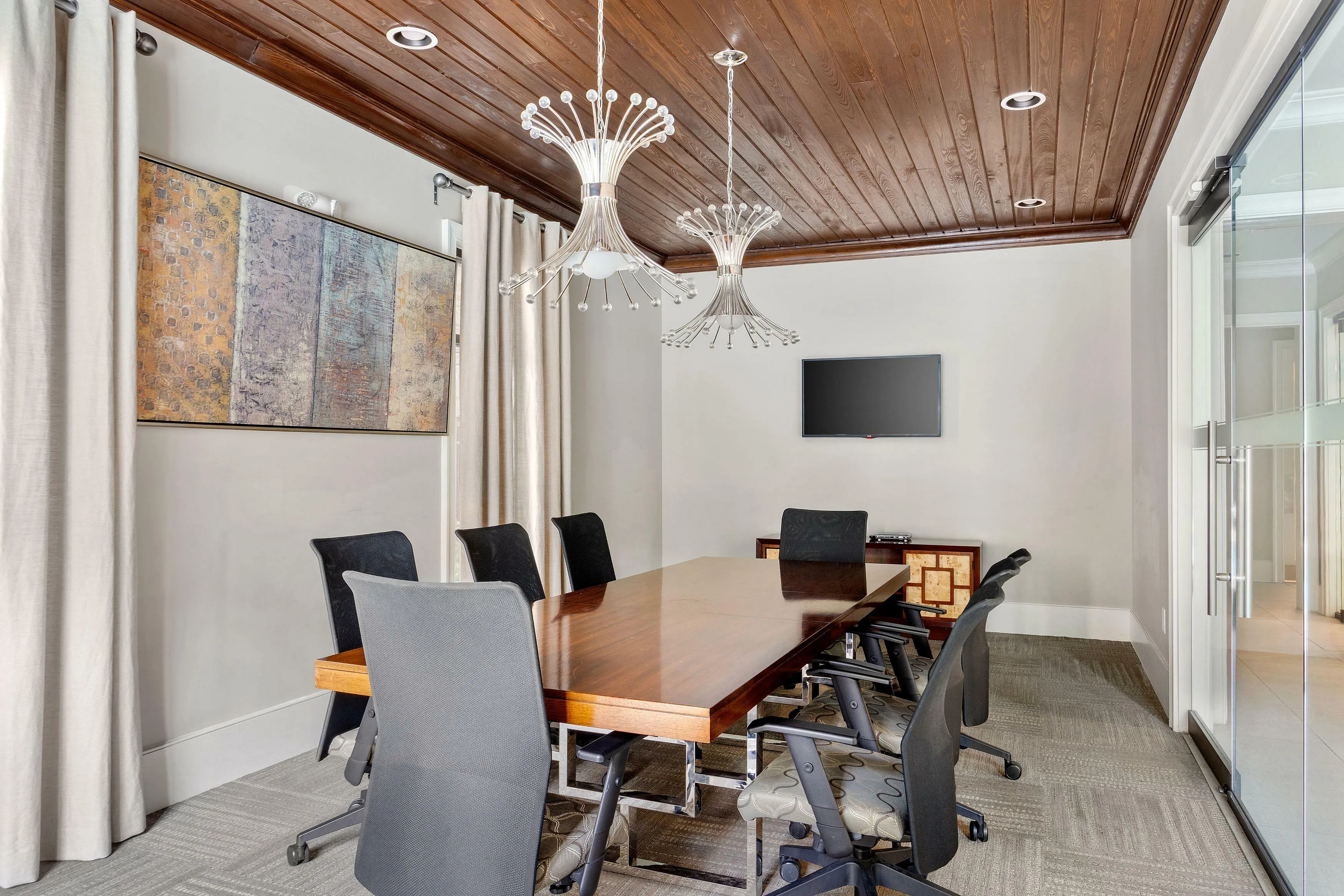 Chic conference room with wooden table, modern chairs, and stylish lighting fixtures.