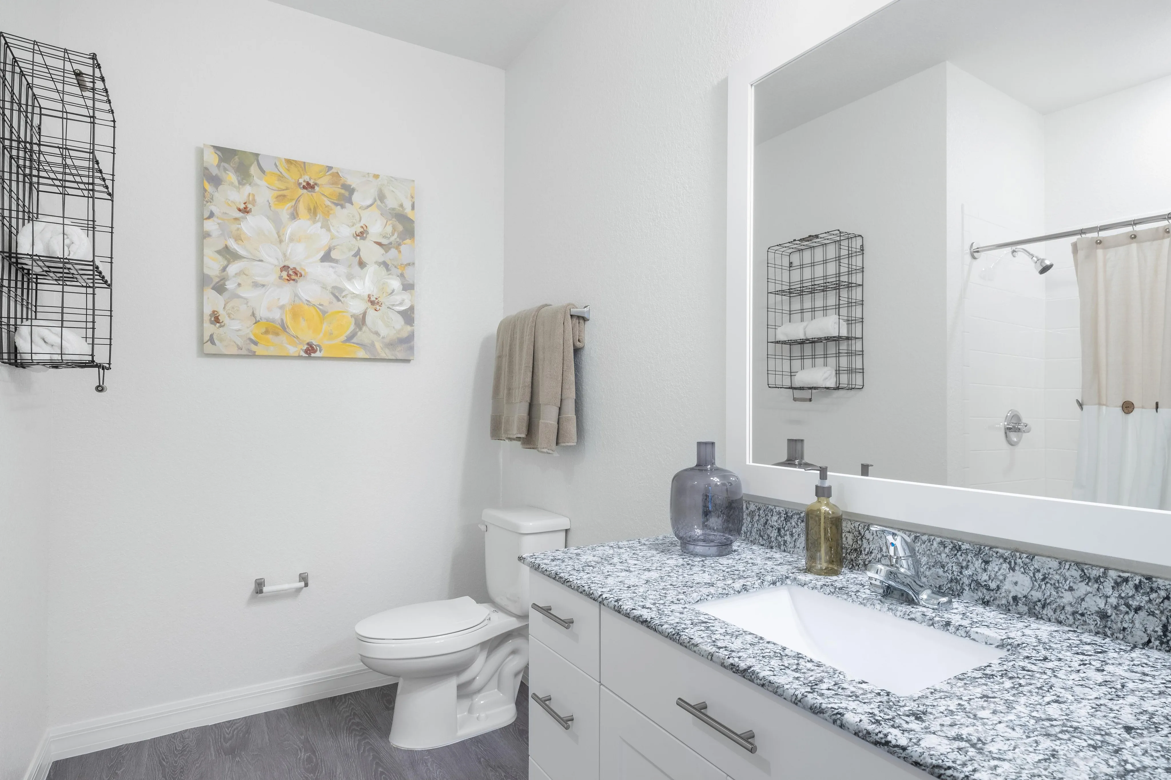 Modern bathroom with granite countertop, wall art, and sleek decor.