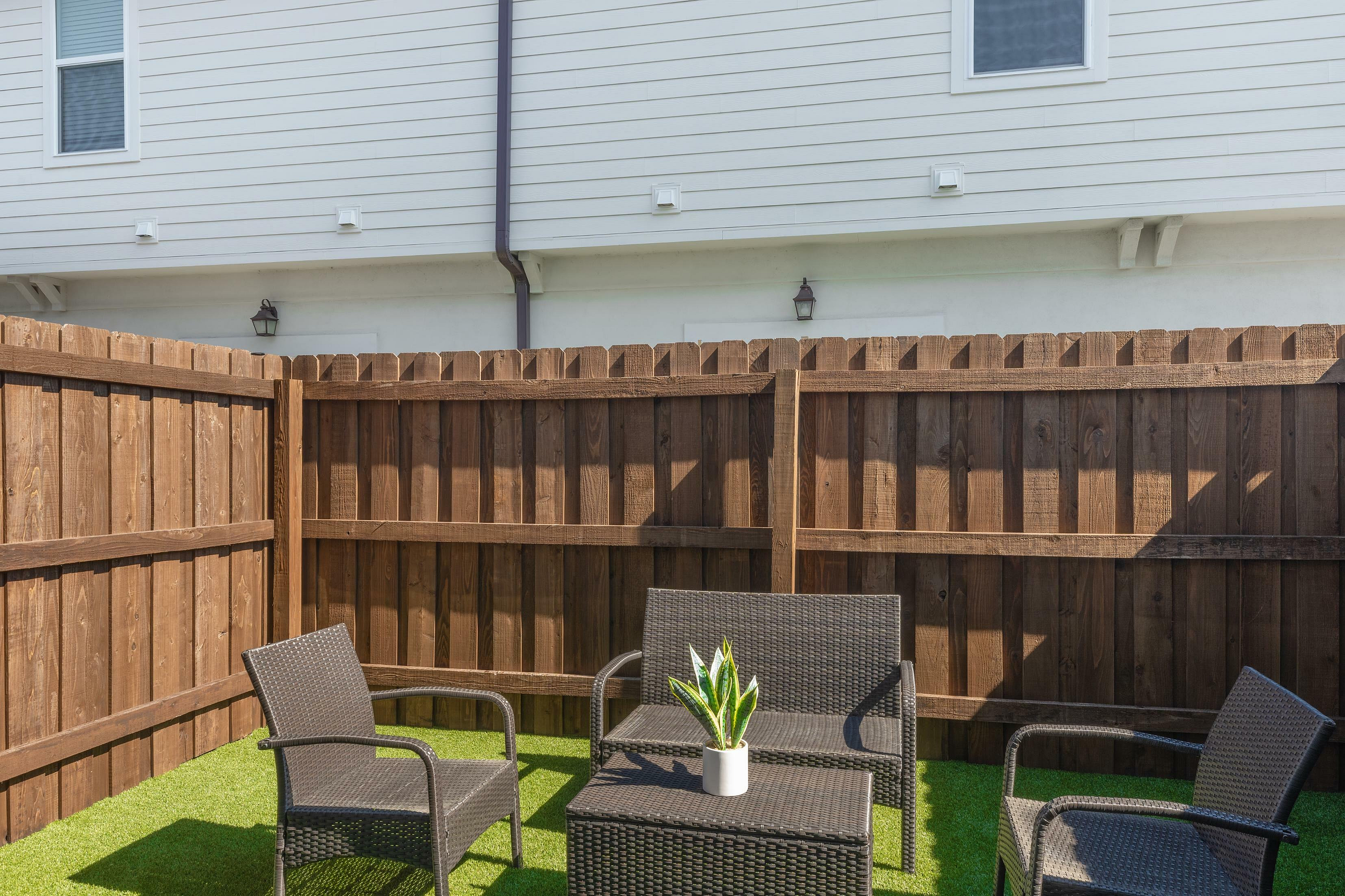 Inviting outdoor patio with wicker seating and vibrant greenery.