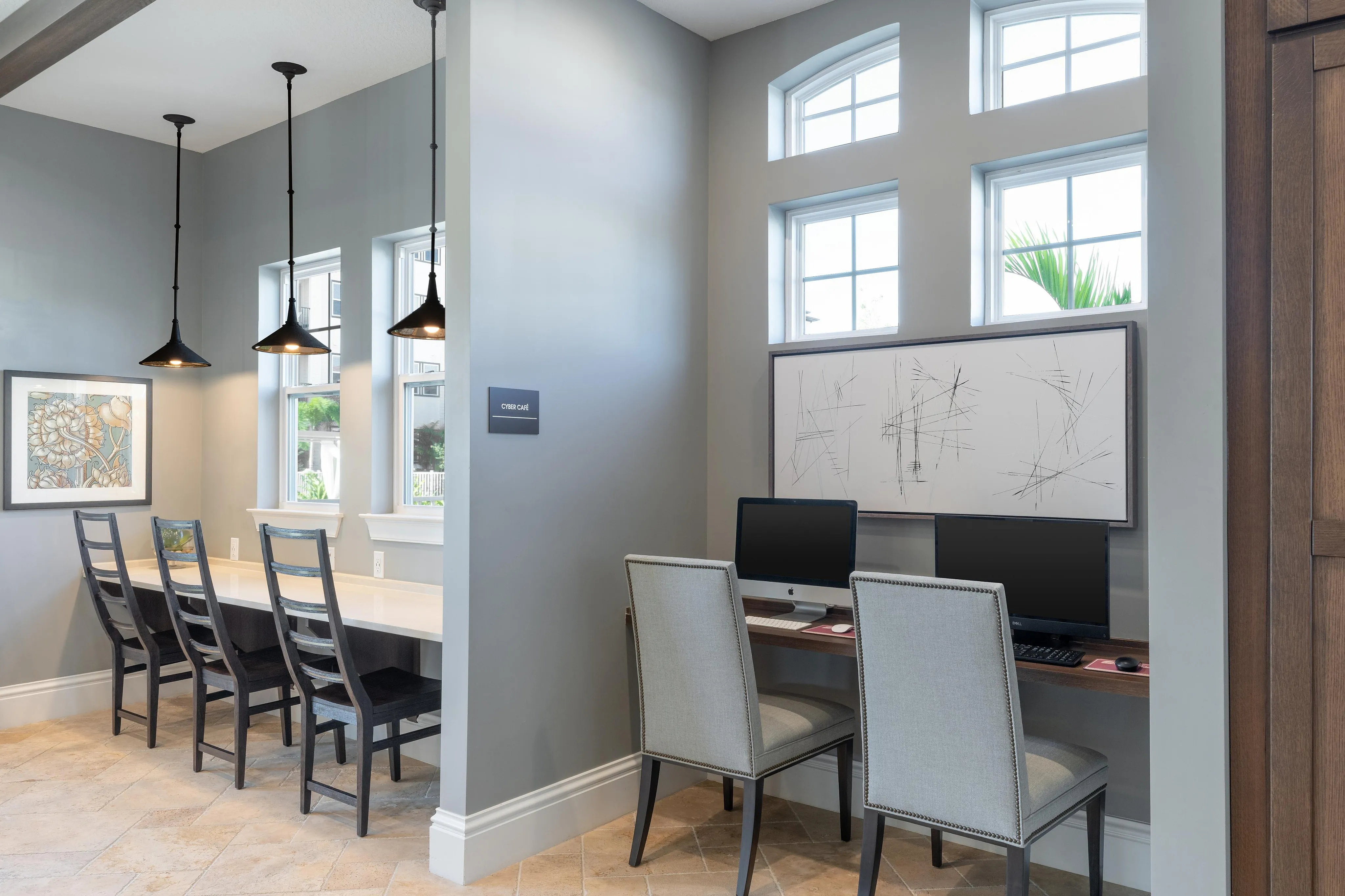 Modern cyber cafe with elegant seating, computers, and contemporary art on the wall.