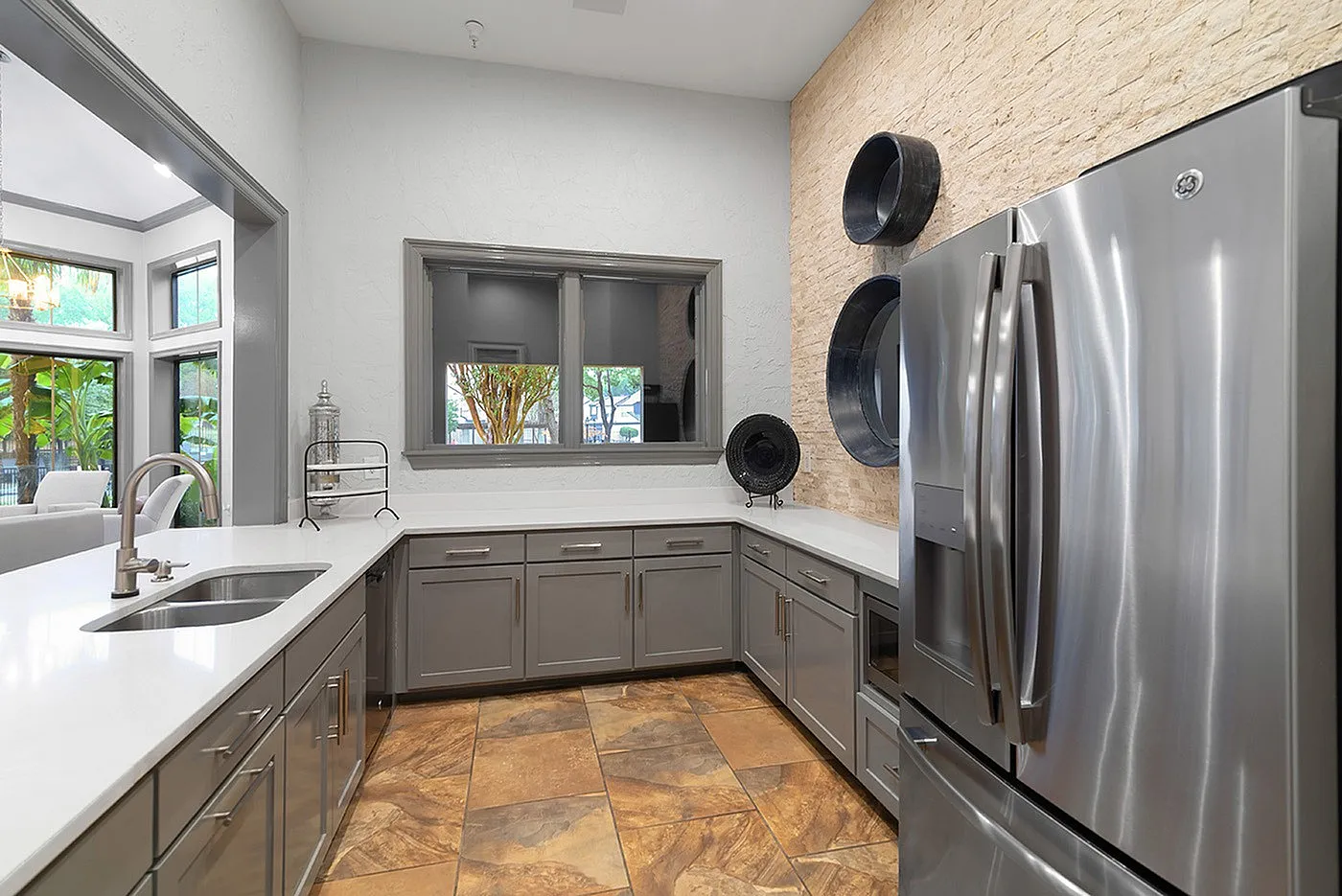 Modern kitchen featuring sleek stainless steel appliances, elegant cabinetry, and natural stone tiles.