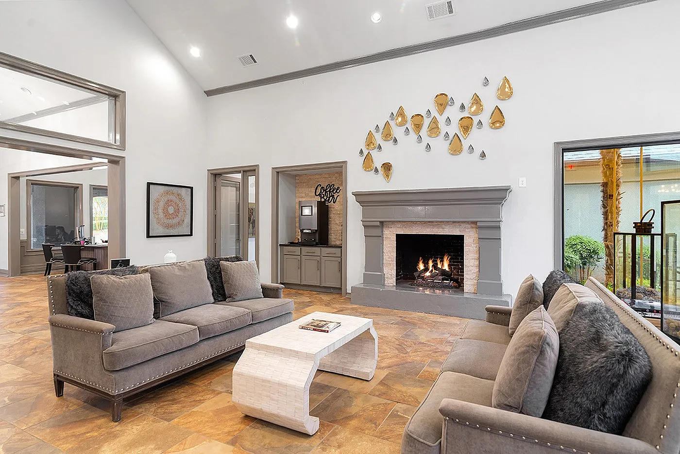 Inviting living room with plush gray sofas, elegant fireplace, and modern decor, perfect for relaxation and social gatherings.