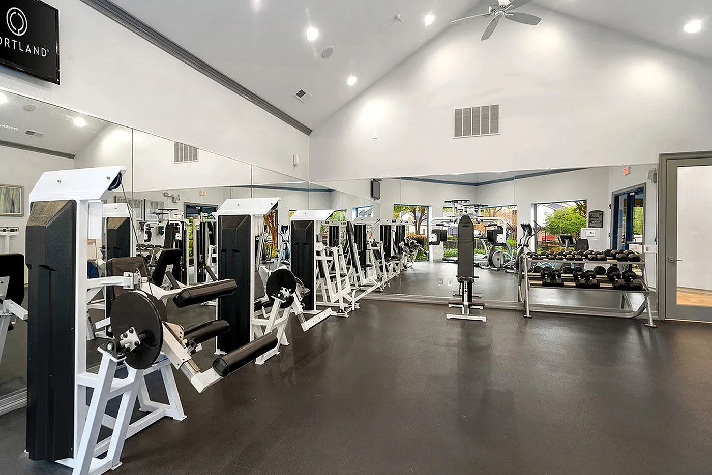 Modern fitness center with state-of-the-art equipment, mirrors, and bright lighting for an invigorating workout experience.