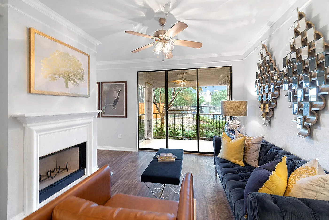 Chic living room with elegant decor, cozy fireplace, and large sliding doors opening to a lush garden view, inviting natural light.