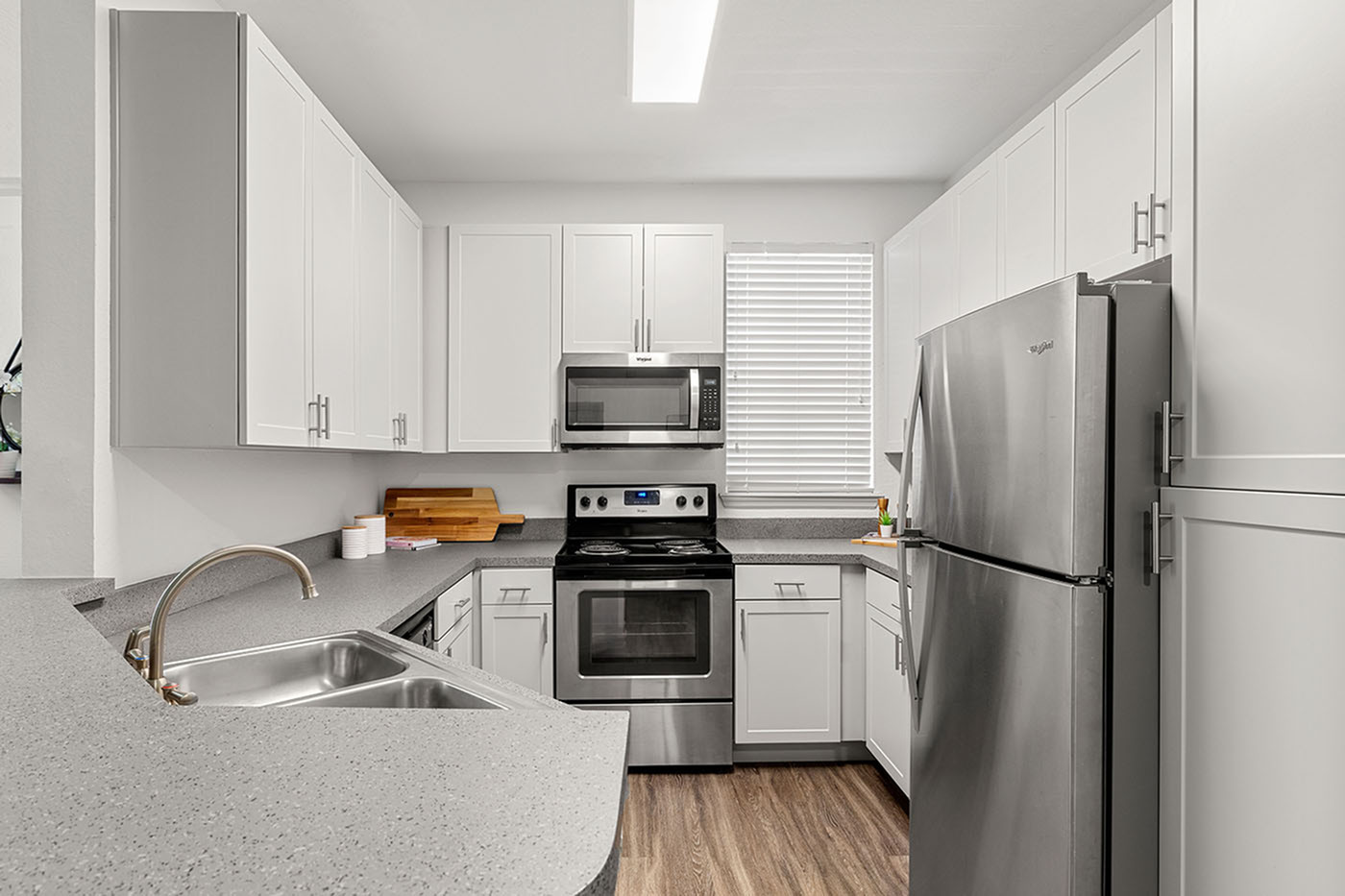 Modern kitchen featuring sleek white cabinetry and stainless steel appliances, perfect for culinary creativity.