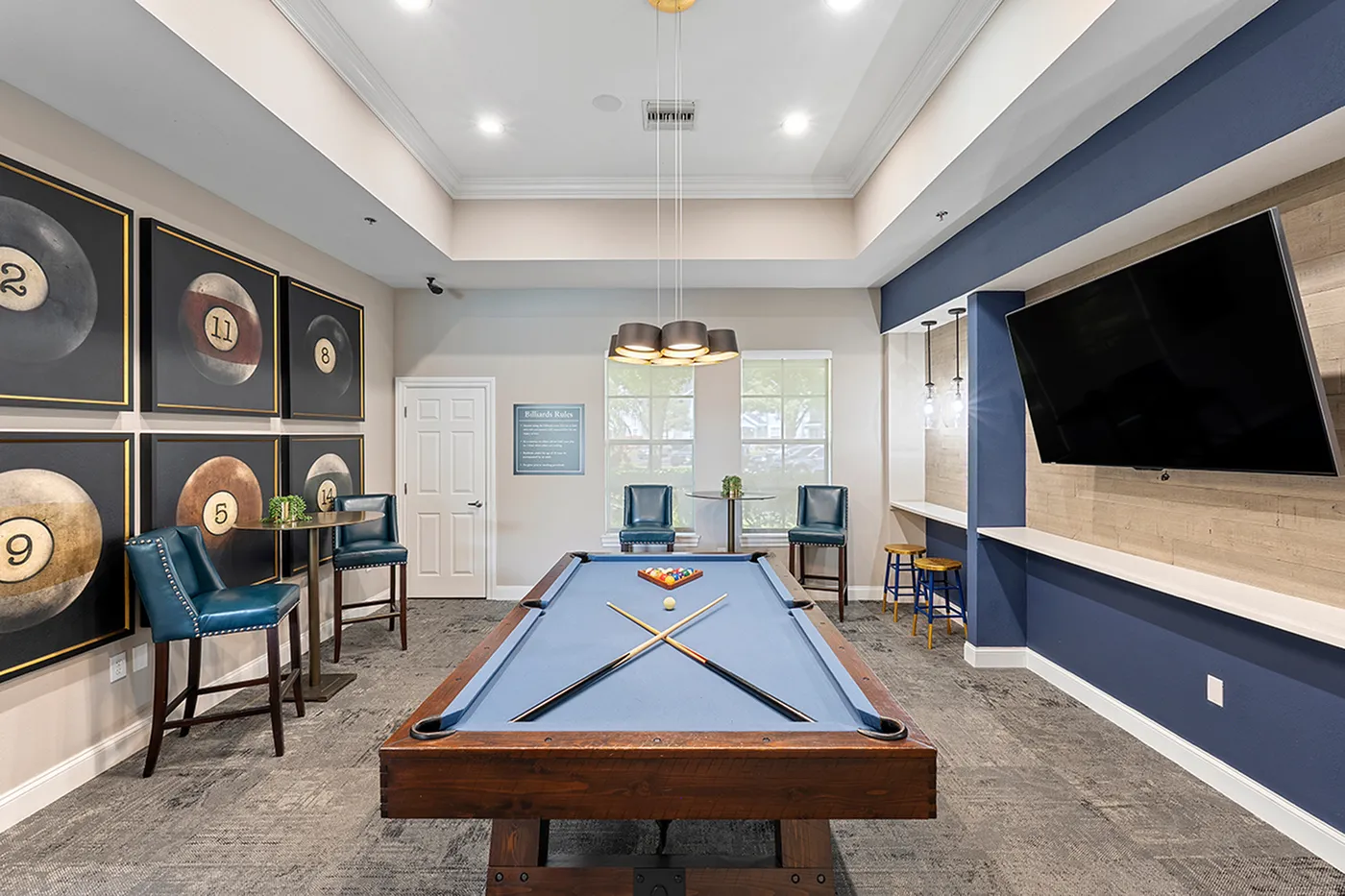 Chic recreation room featuring a stylish pool table, modern artwork, and a comfortable seating area, perfect for entertainment and relaxation.