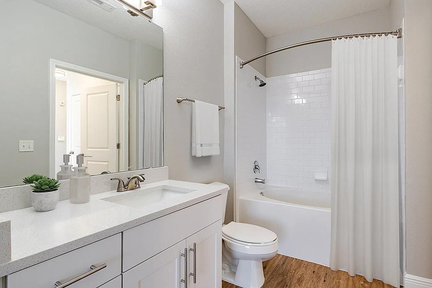 Renovated bathroom with sleek fixtures, elegant vanity, and a pristine bathtub.
