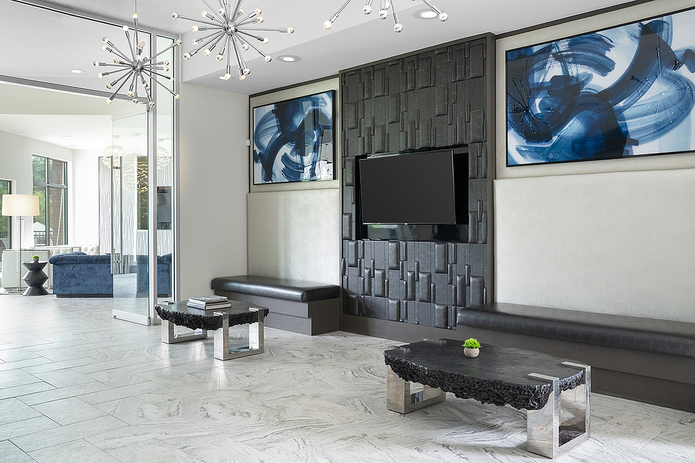 Modern clubhouse with sleek furniture, artistic decor, and striking chandeliers, offering a stylish and inviting ambiance.