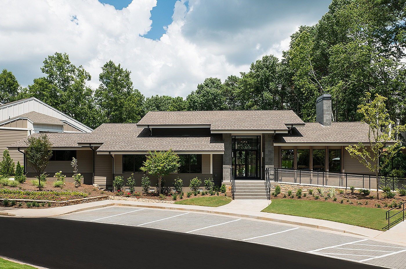 Charming single-story building with modern architecture and lush greenery, perfect for a tranquil lifestyle.
