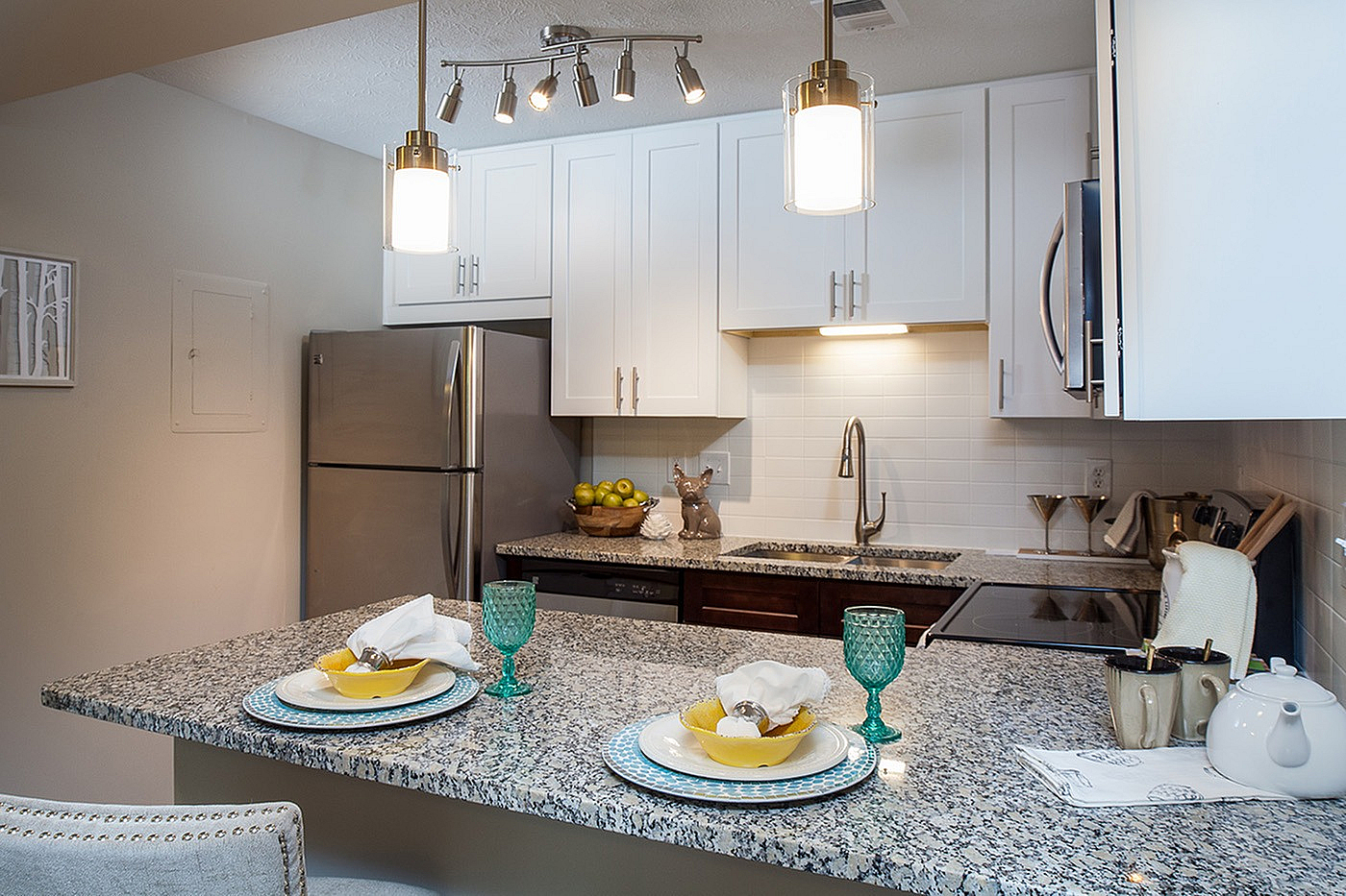 Modern kitchen with sleek granite countertops, stainless steel appliances, and stylish pendant lighting, perfect for entertaining.