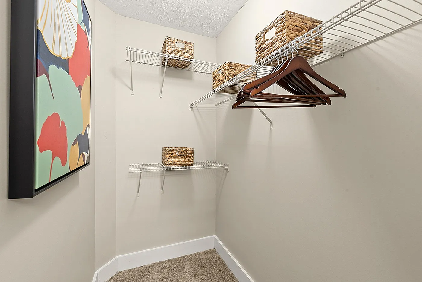 Sleek walk-in closet with modern shelving and tasteful wicker baskets, perfect for organized living.
