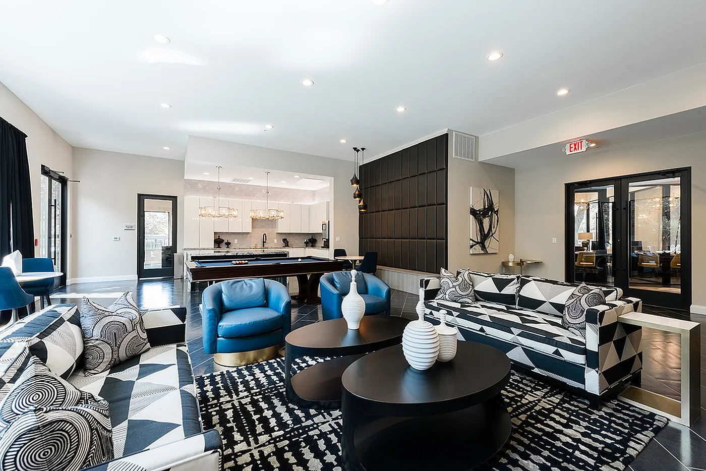 Luxurious open-concept living area with stylish geometric decor, plush seating, and a modern billiard table under elegant pendant lighting.