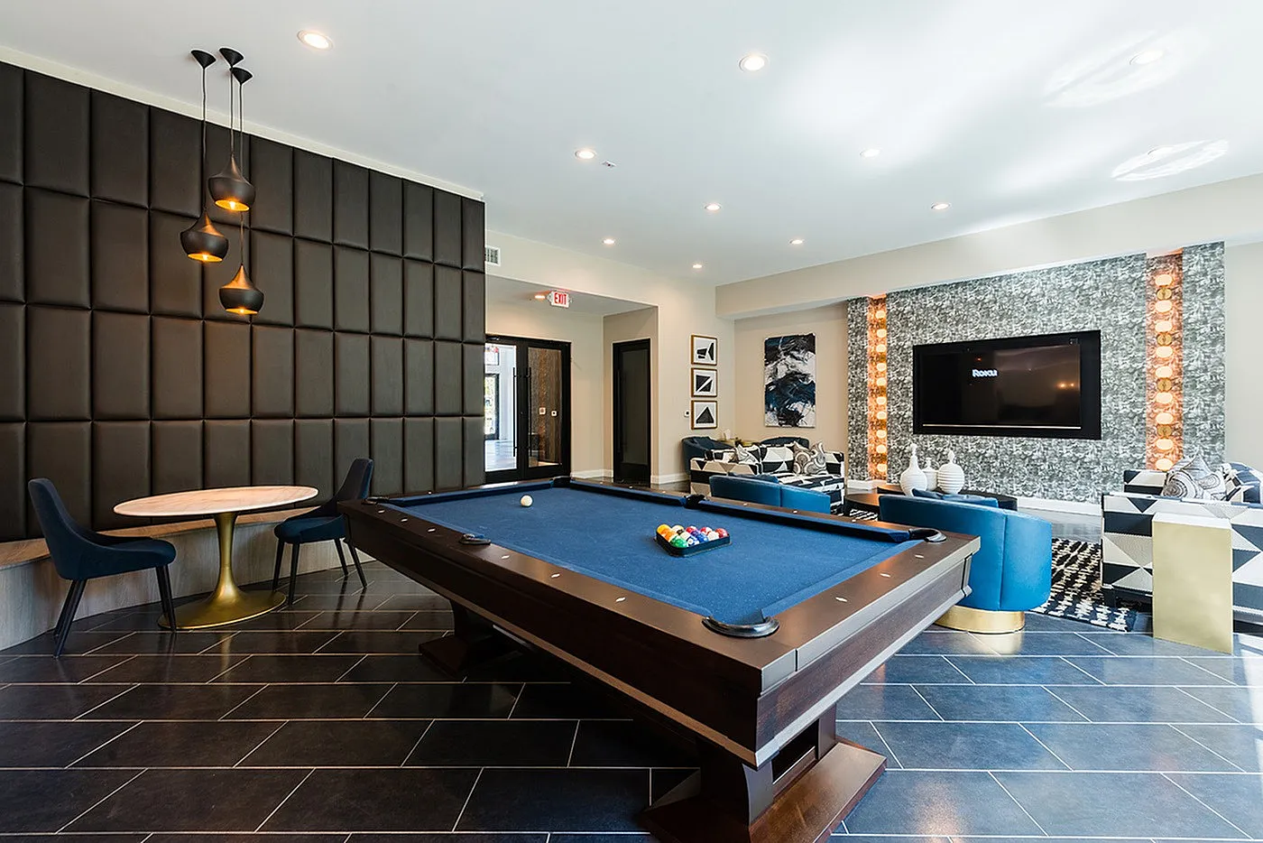 Elegant recreational area featuring a modern pool table, cozy seating, and stylish decor, perfect for relaxation and entertainment.