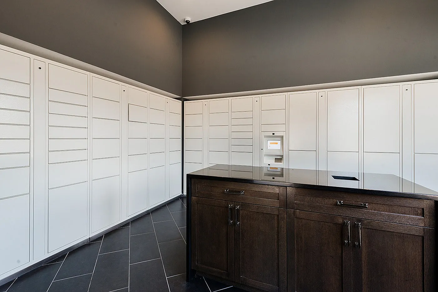 Modern apartment parcel locker area with sleek cabinetry and secure package delivery system.
