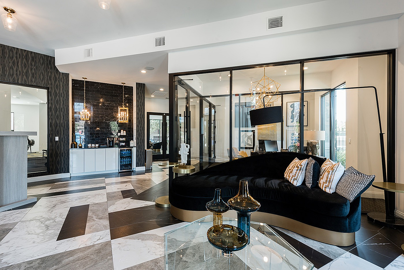 Sophisticated modern living space with sleek black and gold accents, elegant geometric lighting, and cozy seating area.