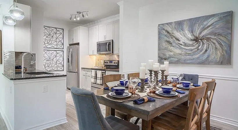 Elegant dining area and modern kitchen with stylish artwork, inviting seating for six, and sleek stainless steel appliances.