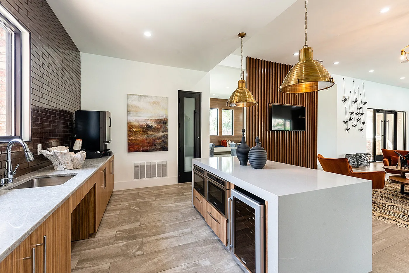 Luxurious modern kitchen and living area featuring sleek countertops, elegant pendant lighting, and chic decor accents.