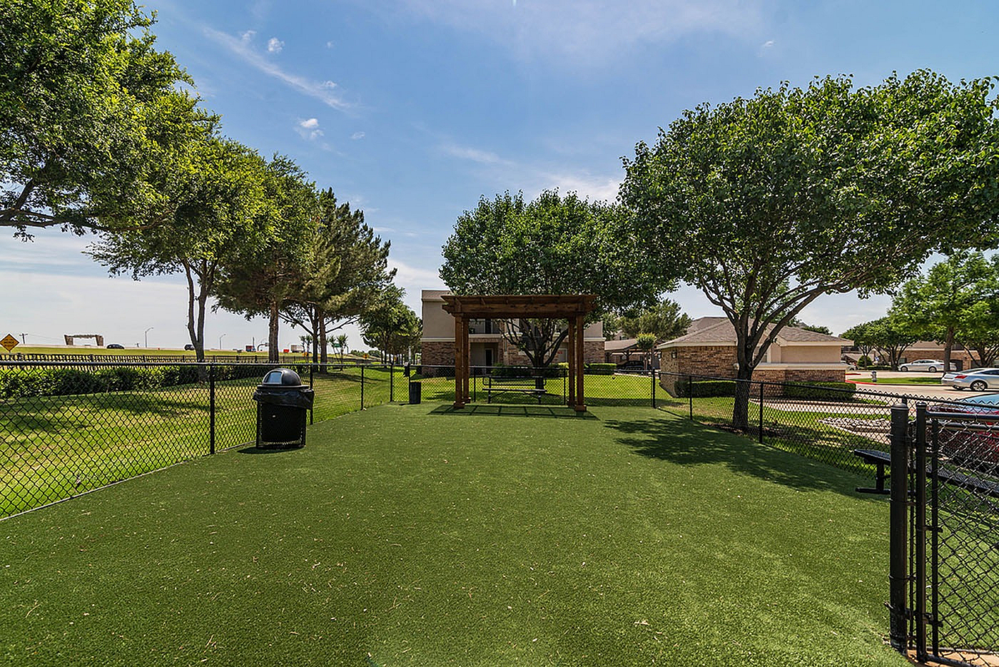 Inviting outdoor space with lush greenery, pergola, and fencing, perfect for relaxation or gatherings.