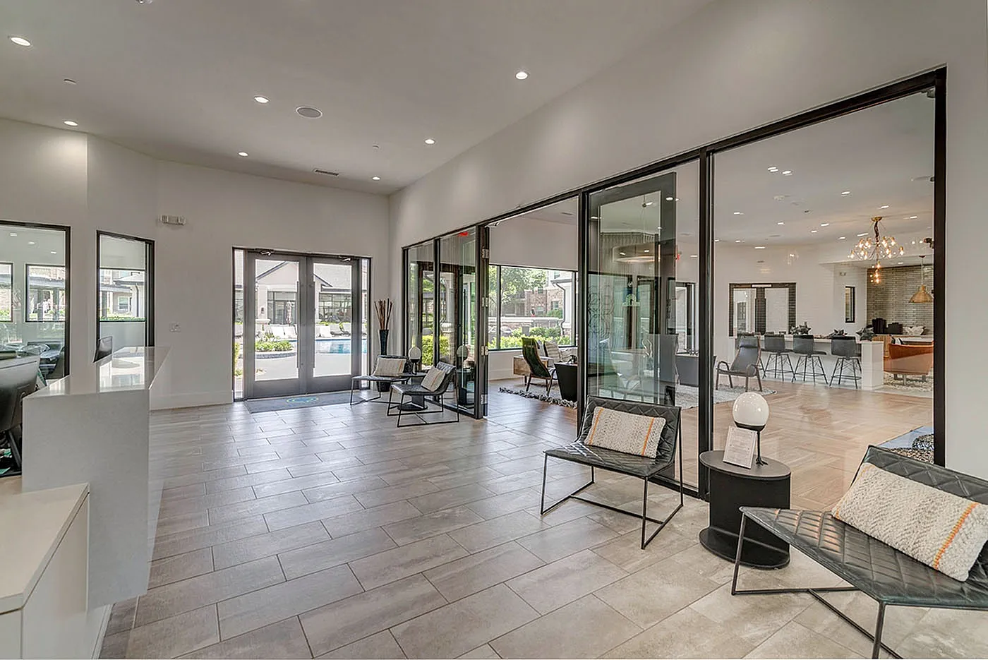 Modern and inviting communal area with sleek furniture, large glass doors opening to a scenic outdoor view, and bright natural lighting.