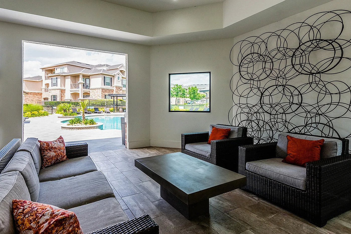 Elegant indoor lounge with stylish seating, modern decor, and a view of the inviting pool and garden area.