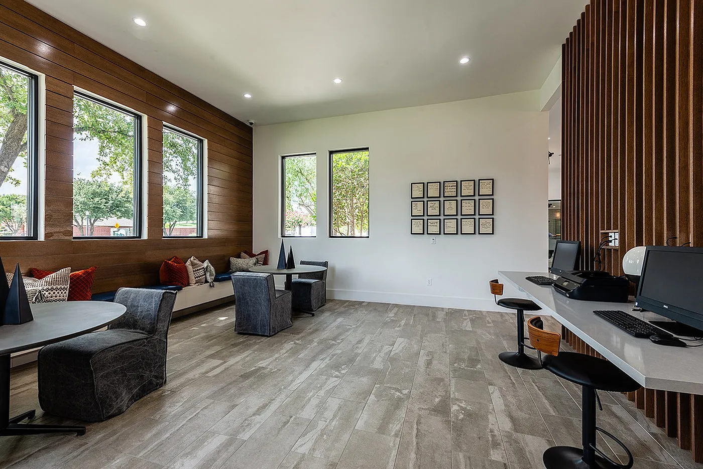 Inviting office space with cozy seating, modern decor, ample natural light through large windows, and sleek computer stations for productivity.