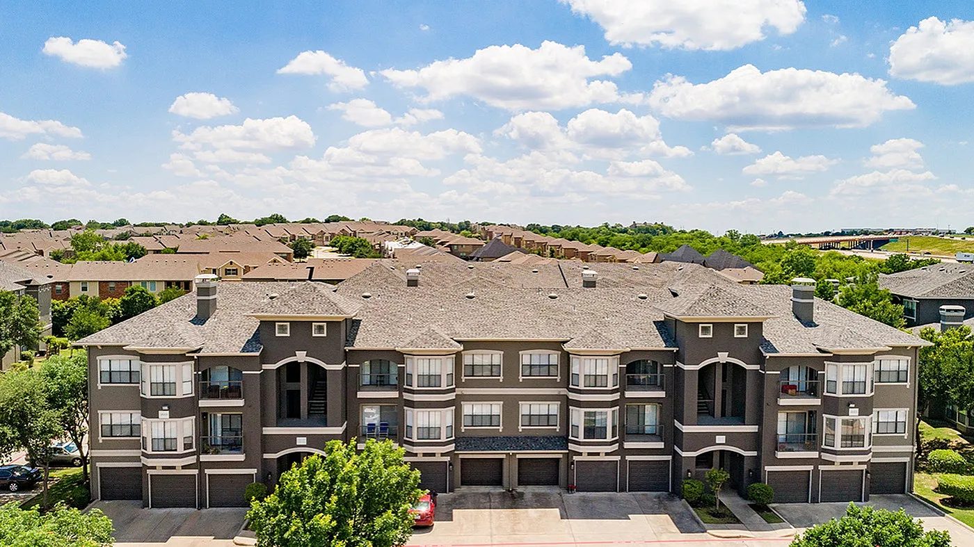 Elegant apartment complex nestled in a serene suburban neighborhood, featuring modern architecture with multiple balconies and lush greenery.