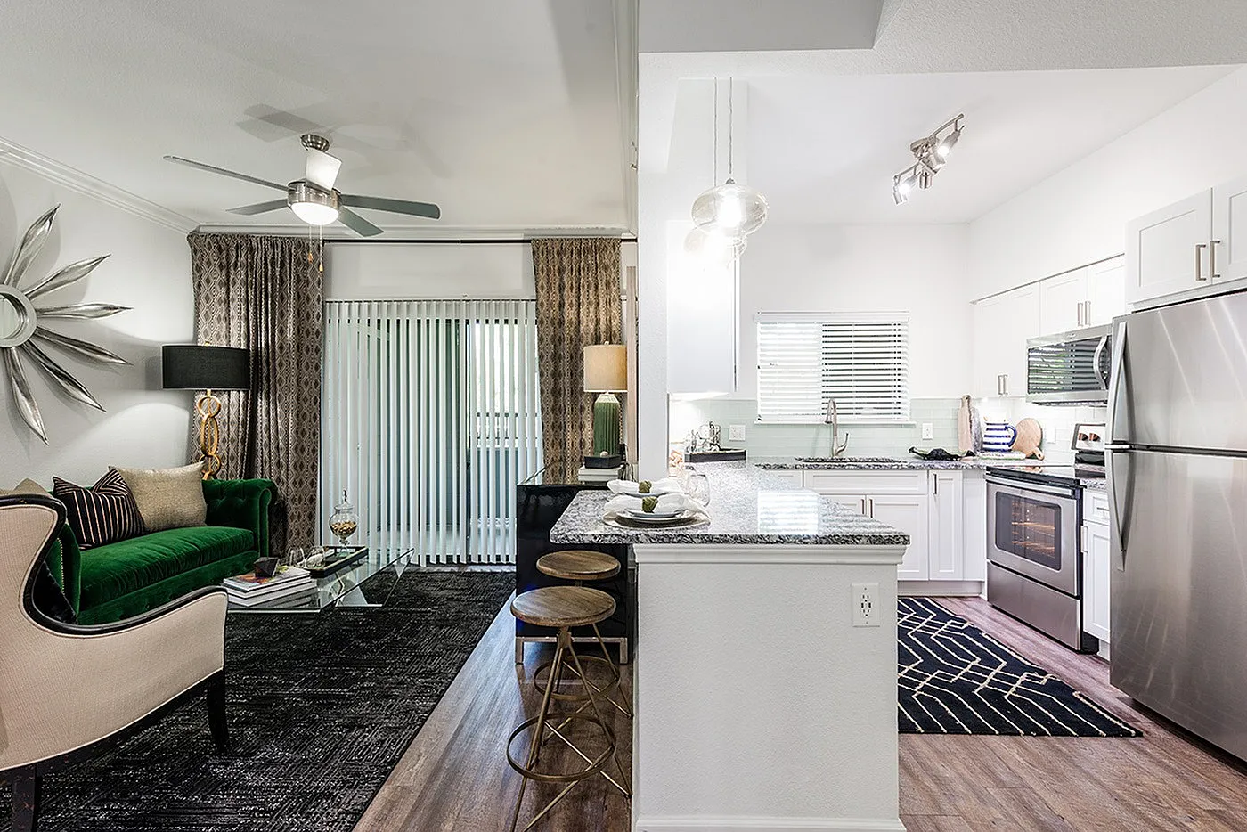 Elegant open-concept living area blending modern kitchen with granite countertops and chic living room featuring plush seating and stylish decor.