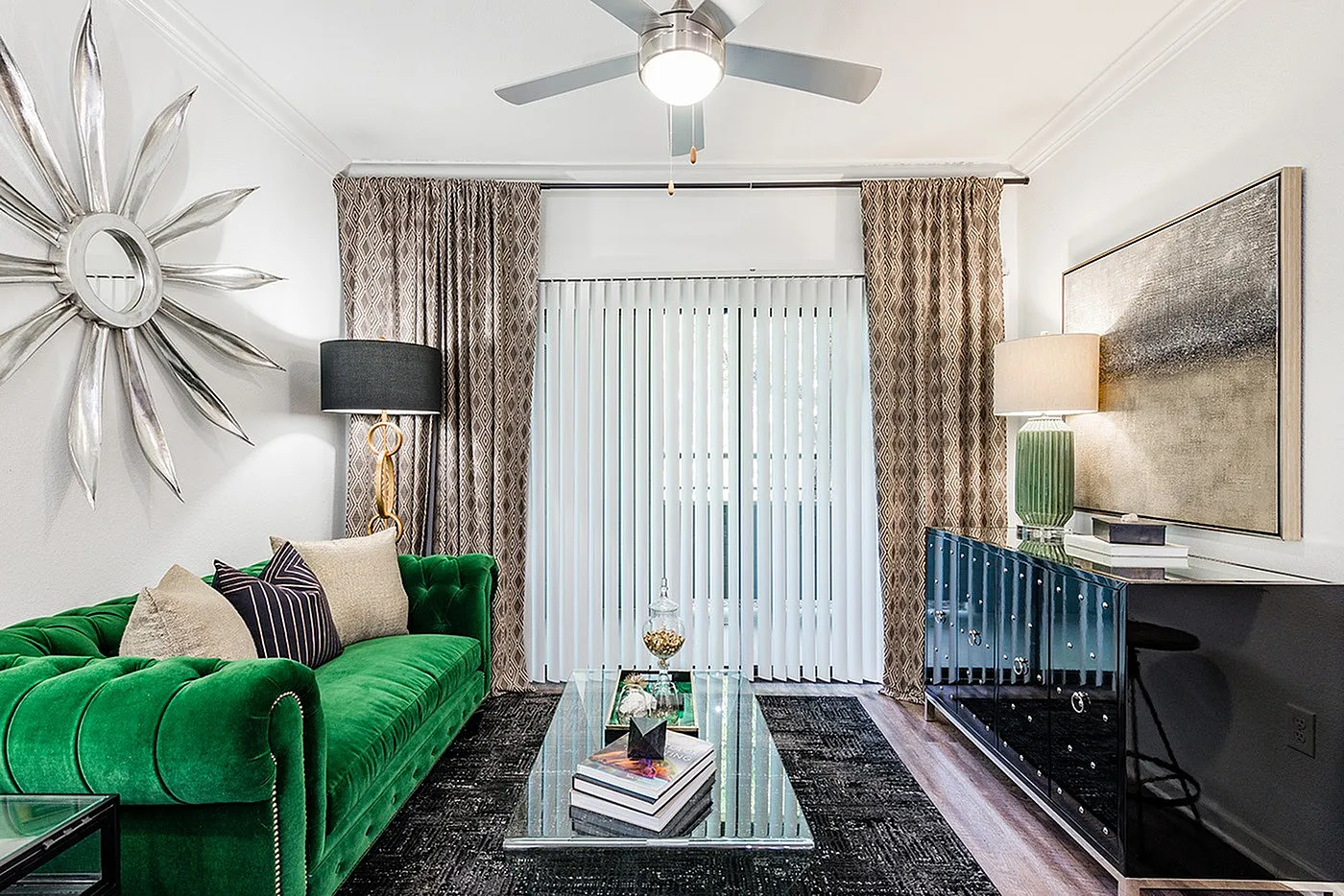 Chic and modern living room with a vibrant green velvet sofa, stylish decor, and natural light filtering through elegant curtains.