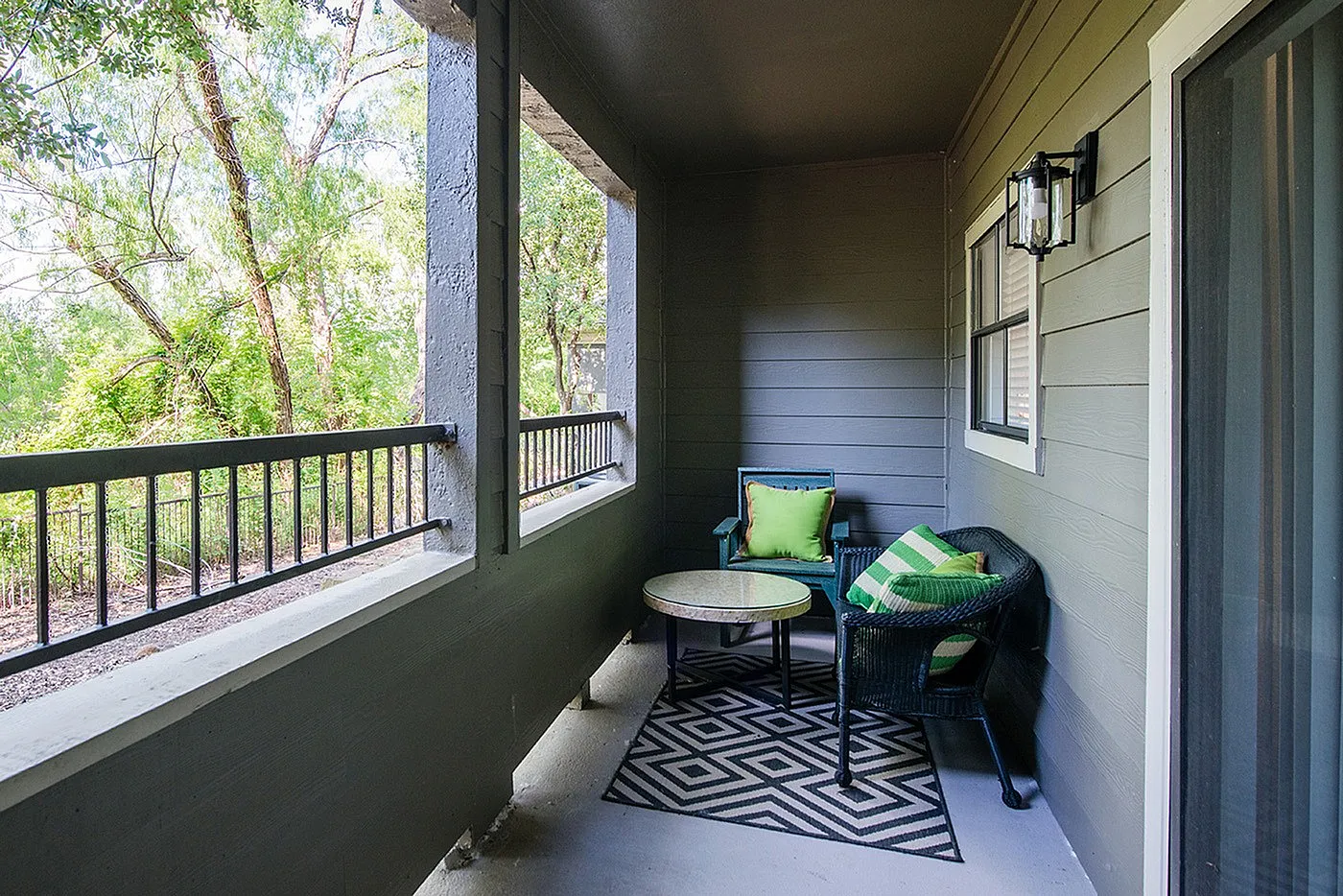 Charming patio with cozy seating area, surrounded by lush greenery, perfect for relaxation.