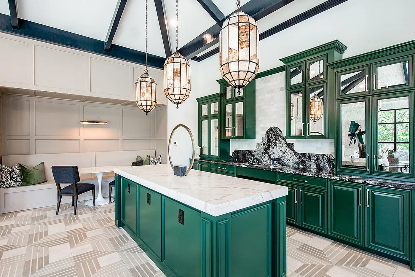 Elegant kitchen with striking green cabinets, luxurious marble countertops, and stylish pendant lighting.