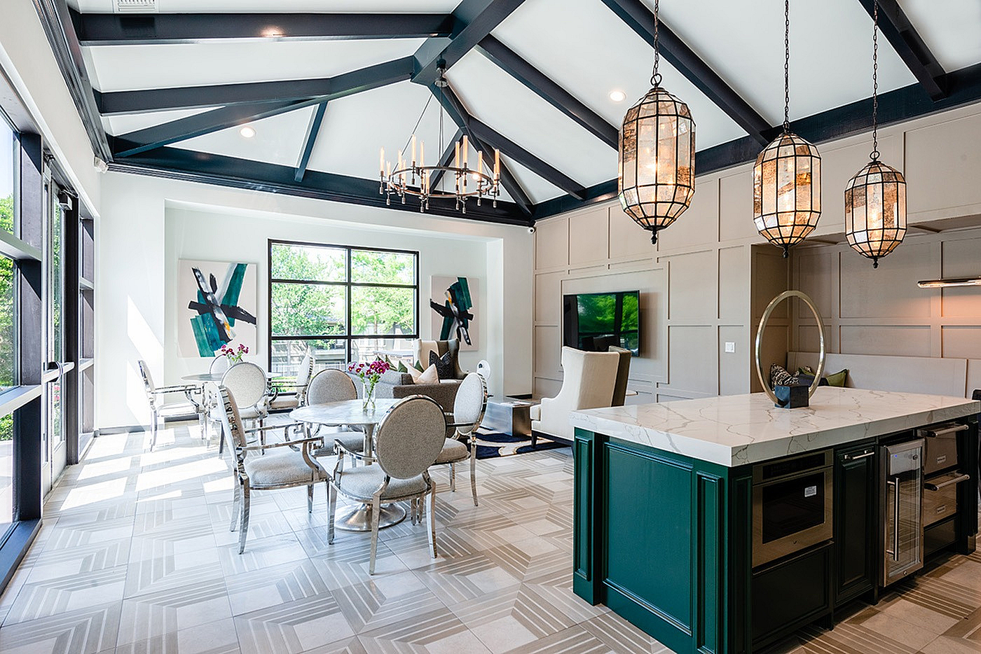 Elegant living space with vaulted beamed ceilings, modern chandeliers, and a stylish open concept kitchen-dining area.
