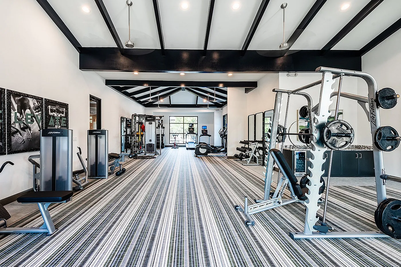 Modern fitness center equipped with state-of-the-art weight machines, sleek design, and vibrant striped flooring.