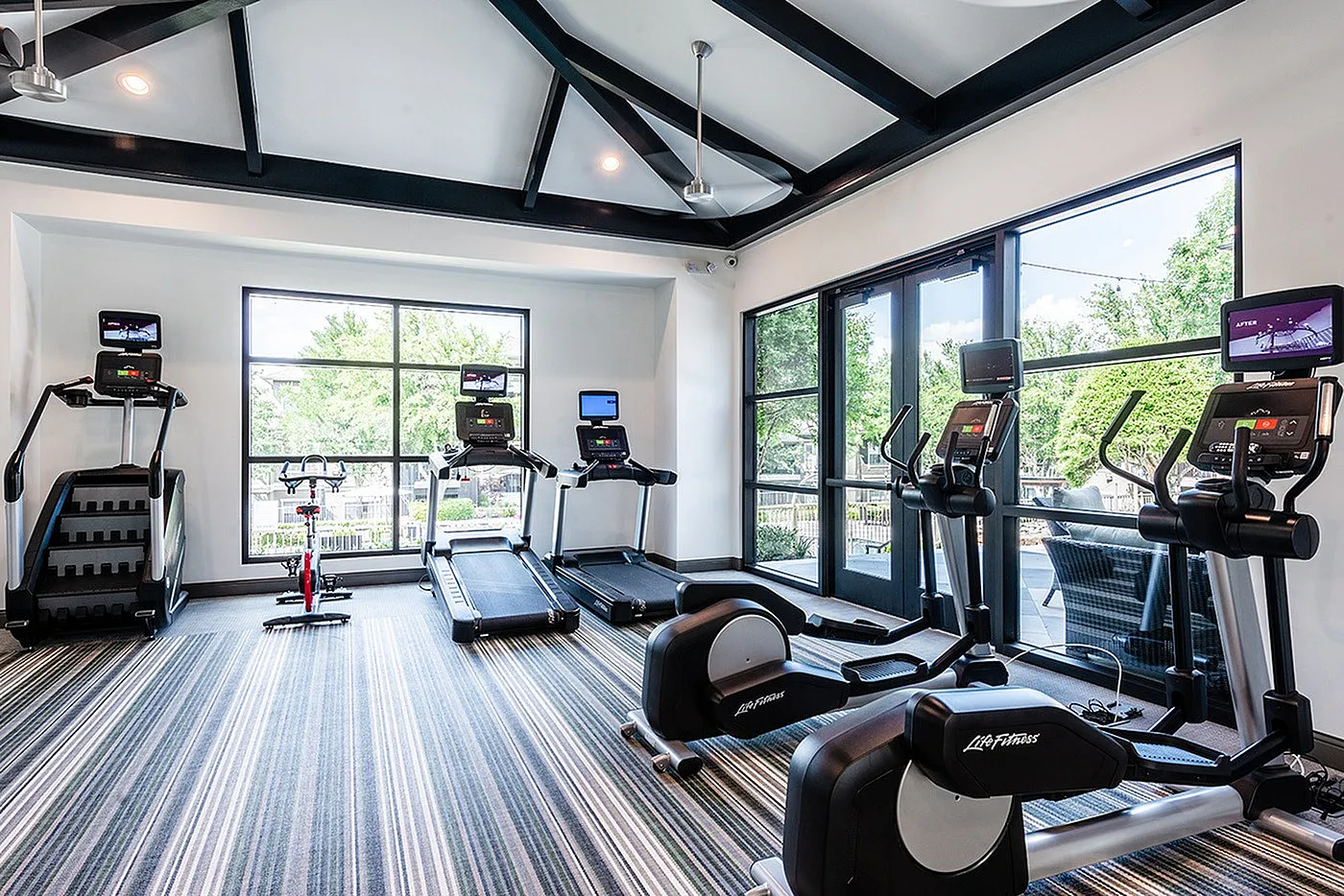 Bright and modern gym area featuring state-of-the-art exercise equipment and scenic outdoor views.