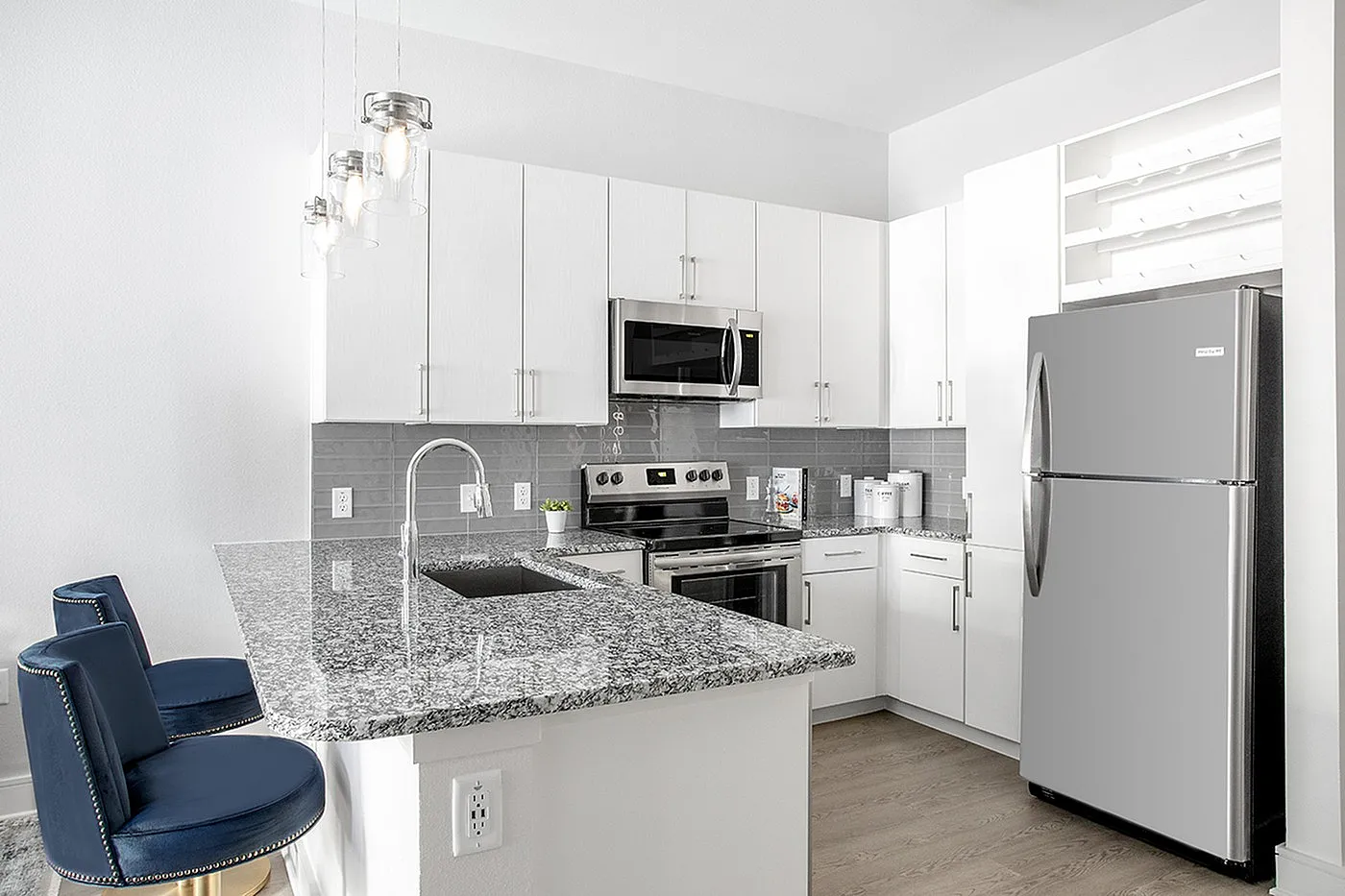 Modern kitchen with sleek stainless steel appliances, elegant granite countertops, and stylish pendant lighting, creating a bright and inviting space.