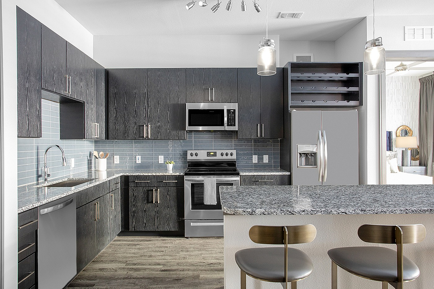 Modern kitchen with sleek dark cabinets, stainless steel appliances, and elegant pendant lighting over a granite breakfast bar.