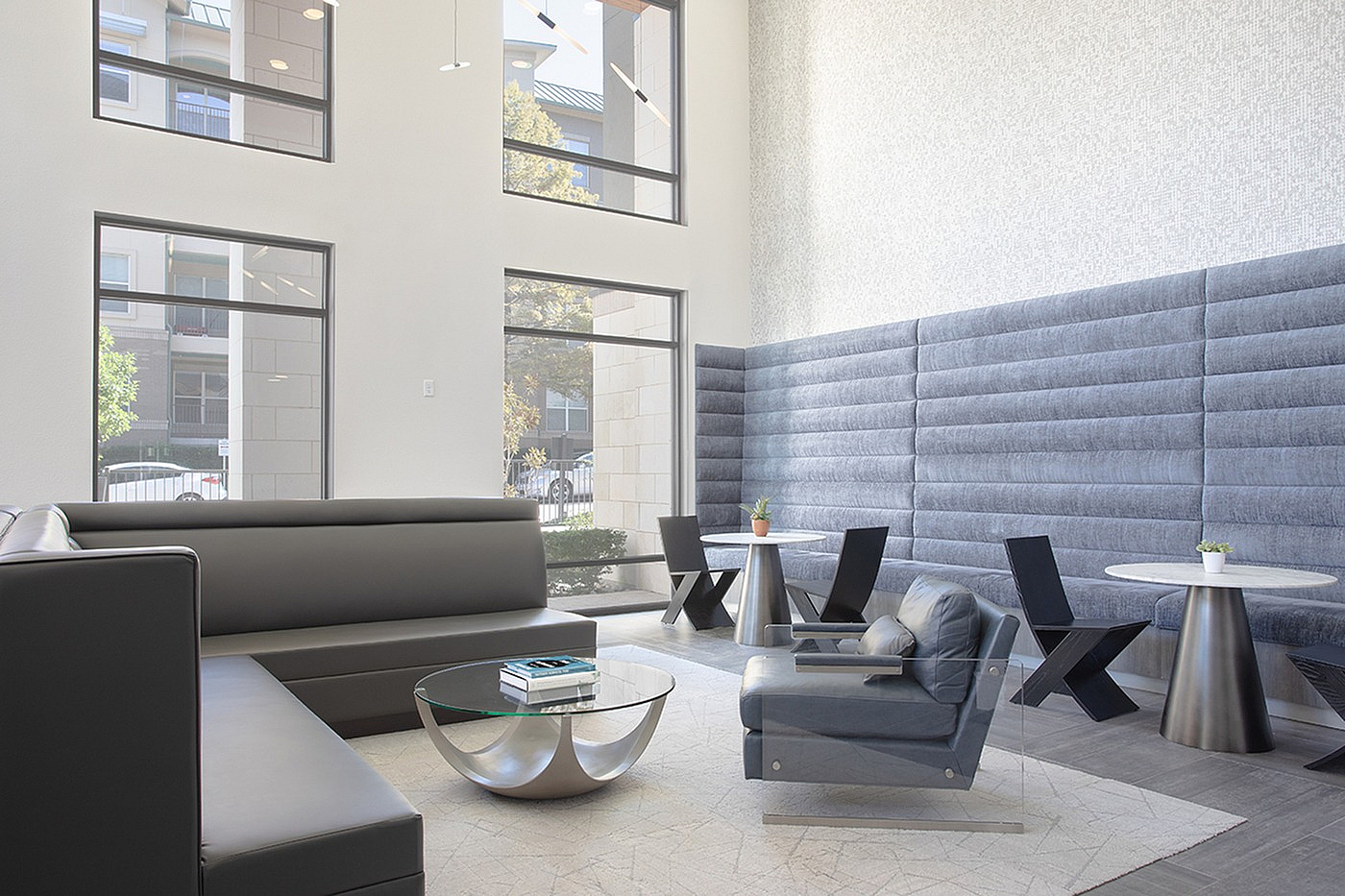 Modern and inviting lounge area with sleek furniture, high ceilings, and abundant natural light from large windows.