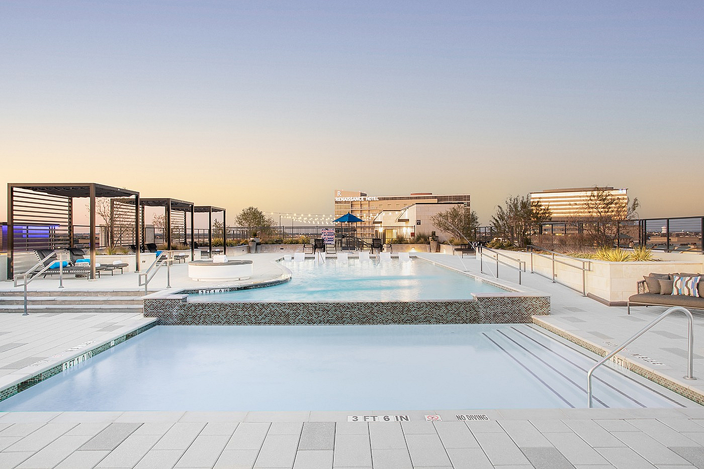 Luxurious rooftop pool with chic cabanas and a stunning cityscape view at sunset, perfect for relaxation and leisure.