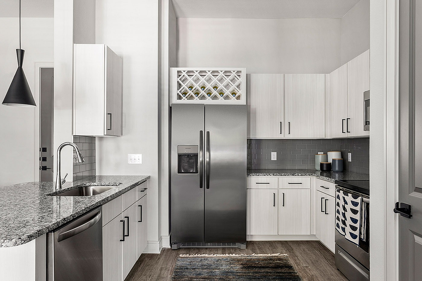 Modern kitchen with sleek stainless steel appliances, elegant granite countertops, and stylish cabinetry offering ample storage.