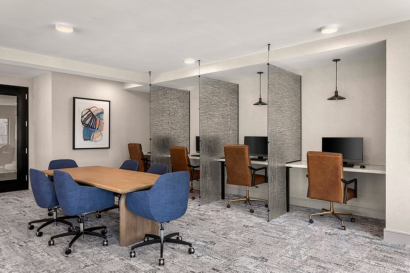 Modern co-working space with stylish meeting table and individual workstations, featuring chic decor and ambient lighting.