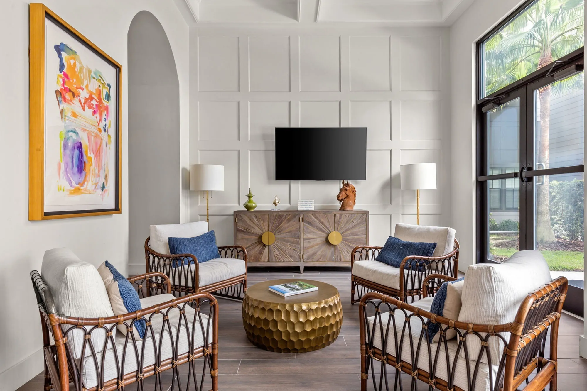 Indoor community living area with cushioned chairs and a television on the wall