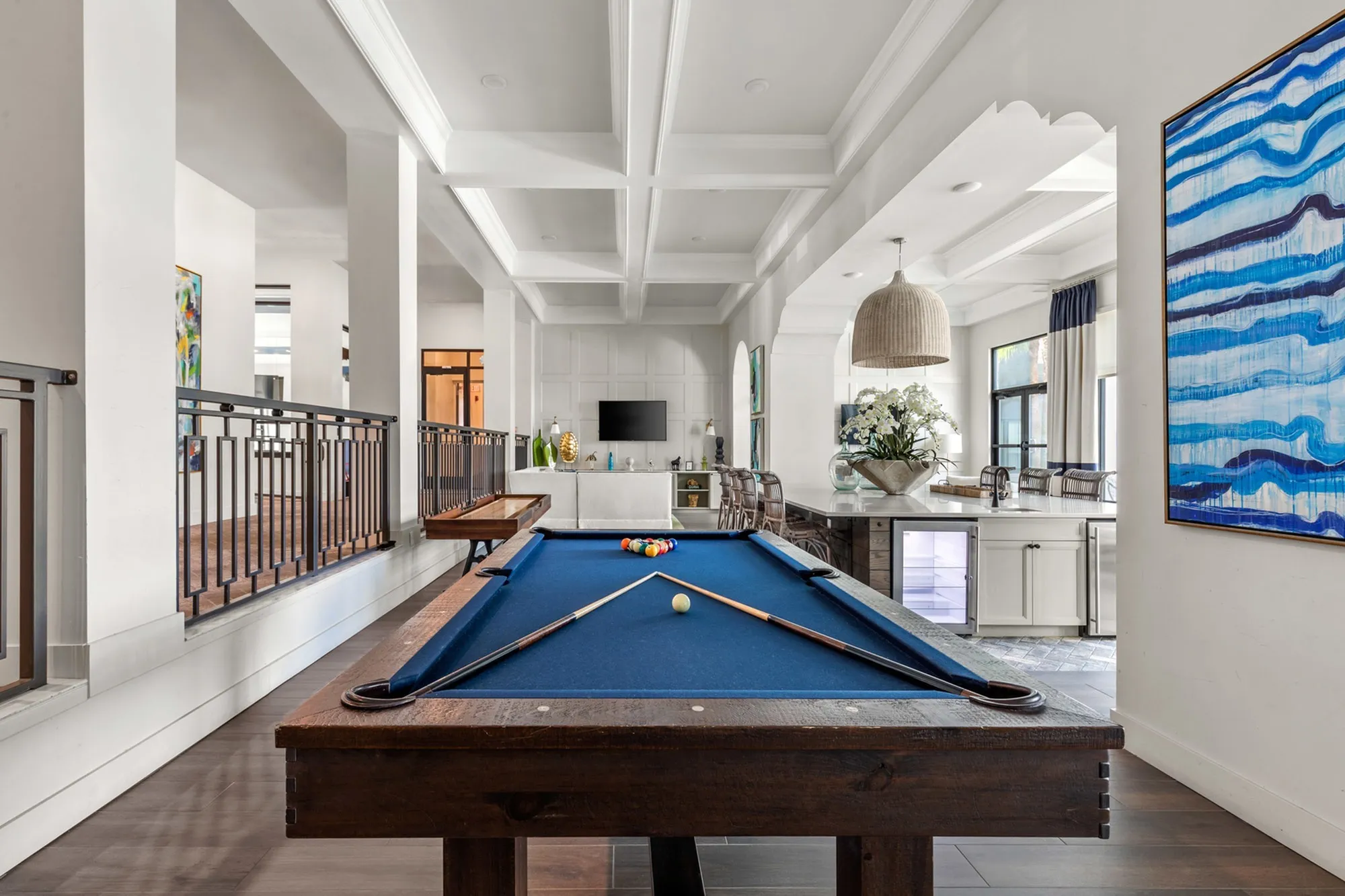 Indoor community area featuring a blue pool table with pool balls and pool sticks