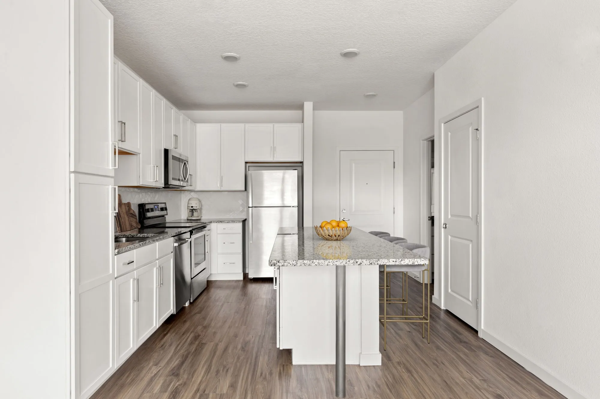 Furnished Kitchen with kitchen island, white cabinets, and stainless steel appliances