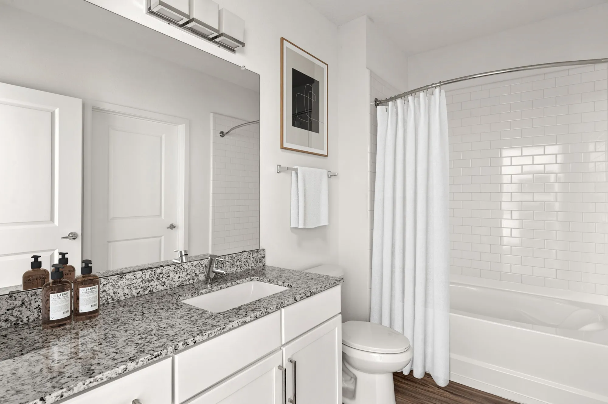 Bathroom with sink and large mirror with a view of the bathtub/shower