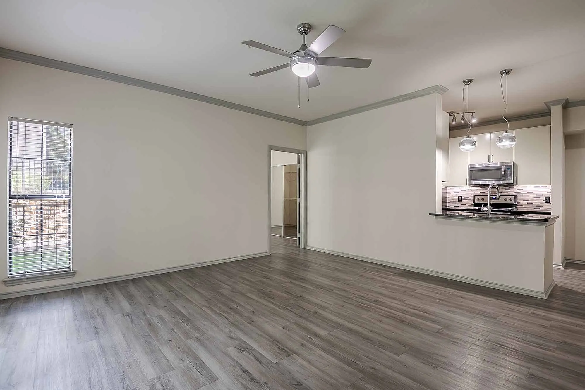 Elegant open-plan living area with modern kitchen, sleek hardwood floors, and stylish lighting fixtures.