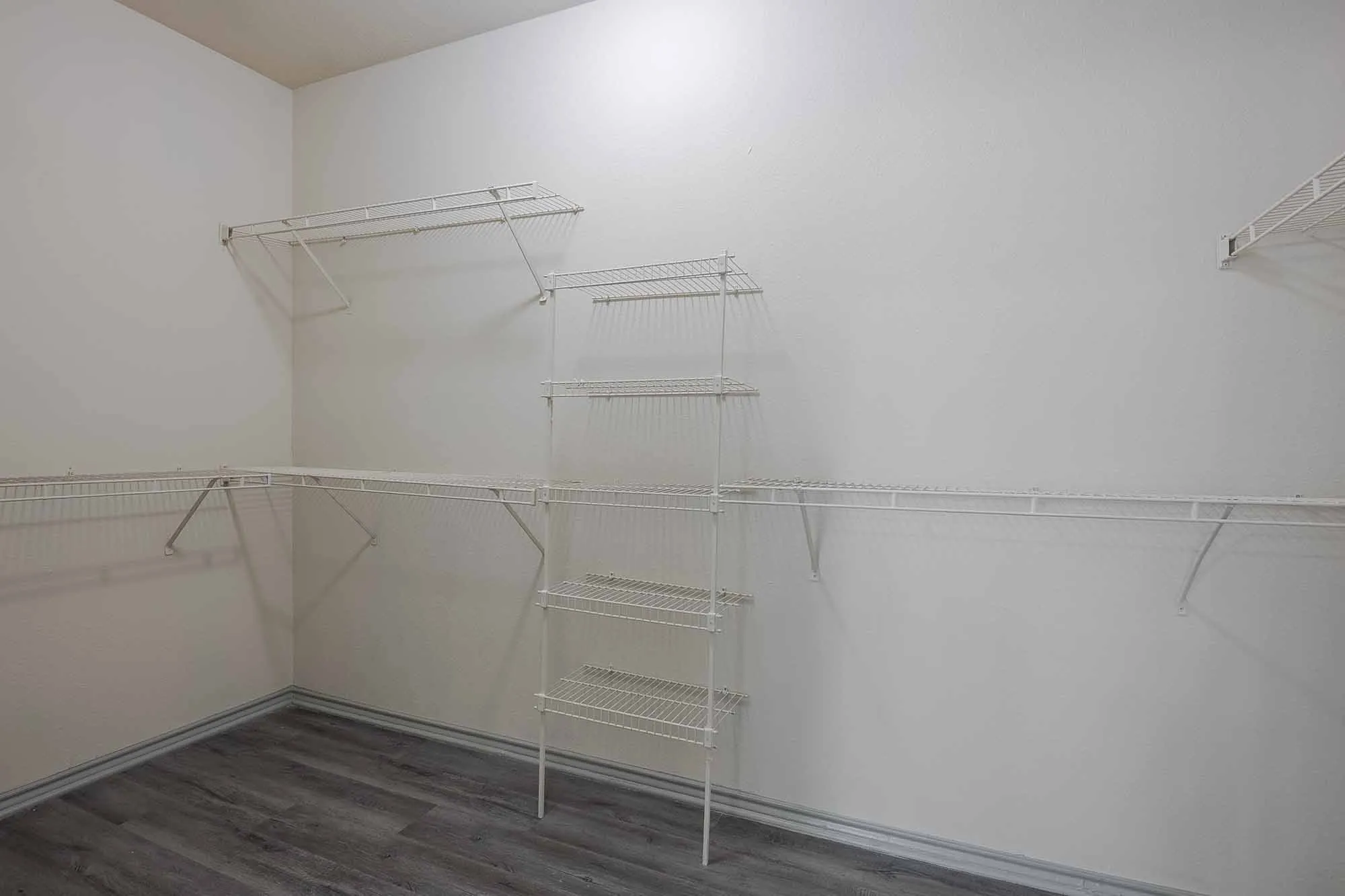 Spacious walk-in closet with sleek wire shelving, perfect for organized storage and maximizing space.