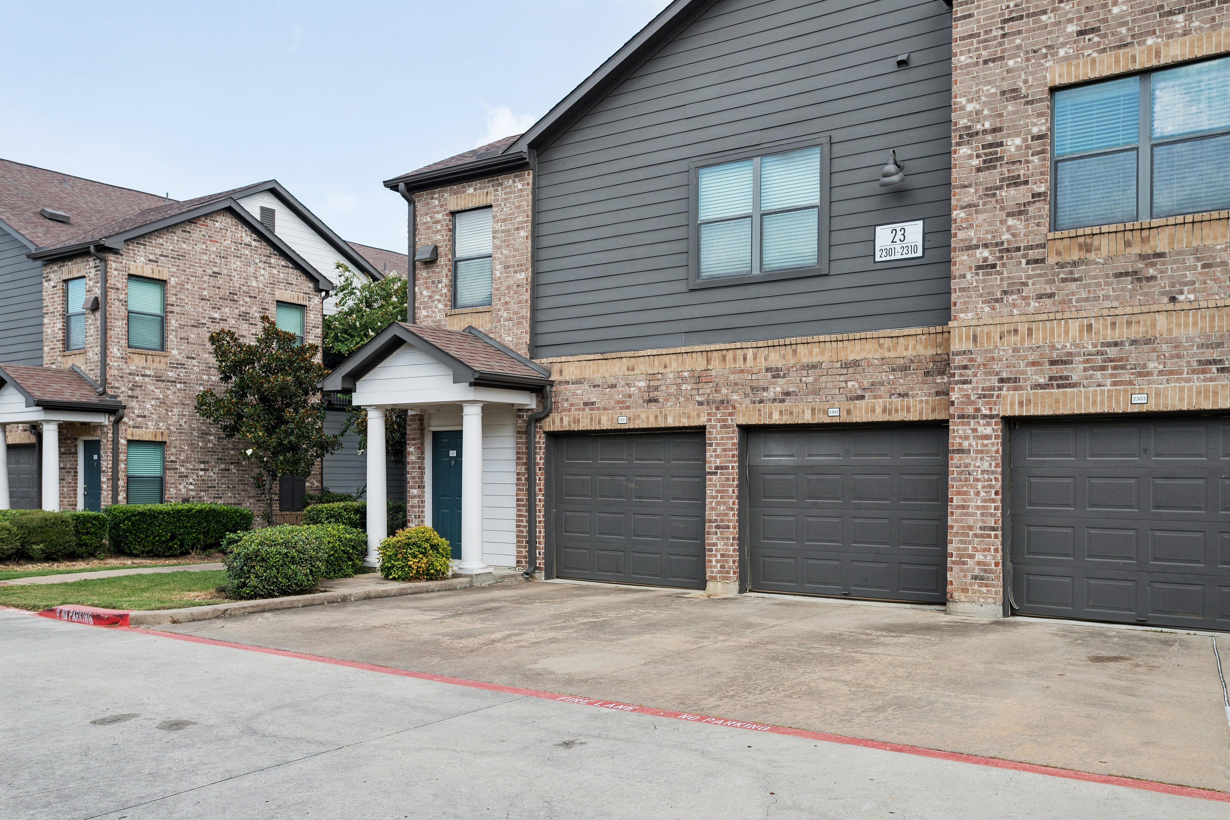 Charming residential building showcasing elegant brick facade, modern architecture, and multiple garage spaces.